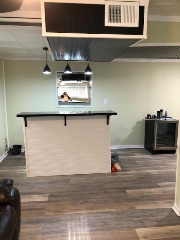 Small basement finish — bar area with pendant lighting and beverage fridge