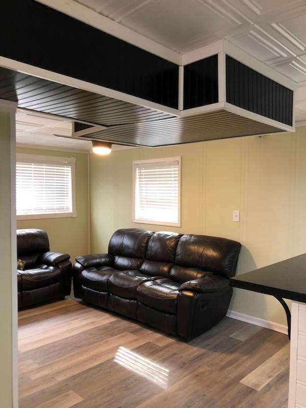 Small basement finish — living area with leather seating and beadboard ceiling